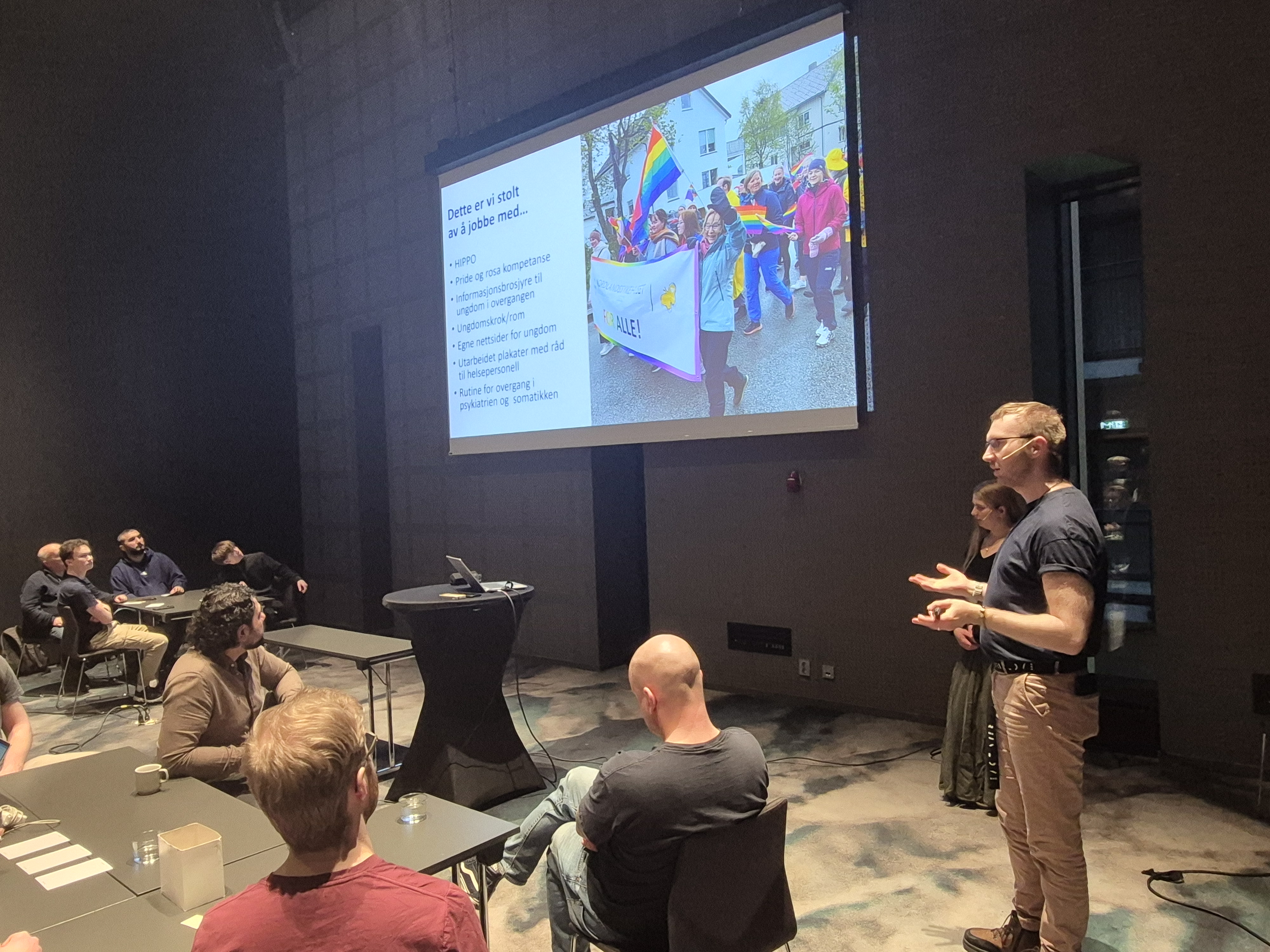 To personer som snakker foran et publikum