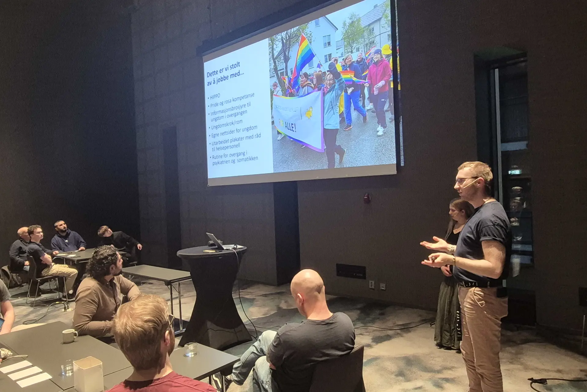 To personer som snakker foran et publikum