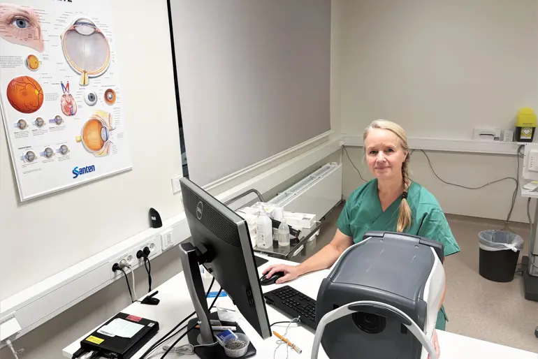 En person som sitter ved et skrivebord med en datamaskin