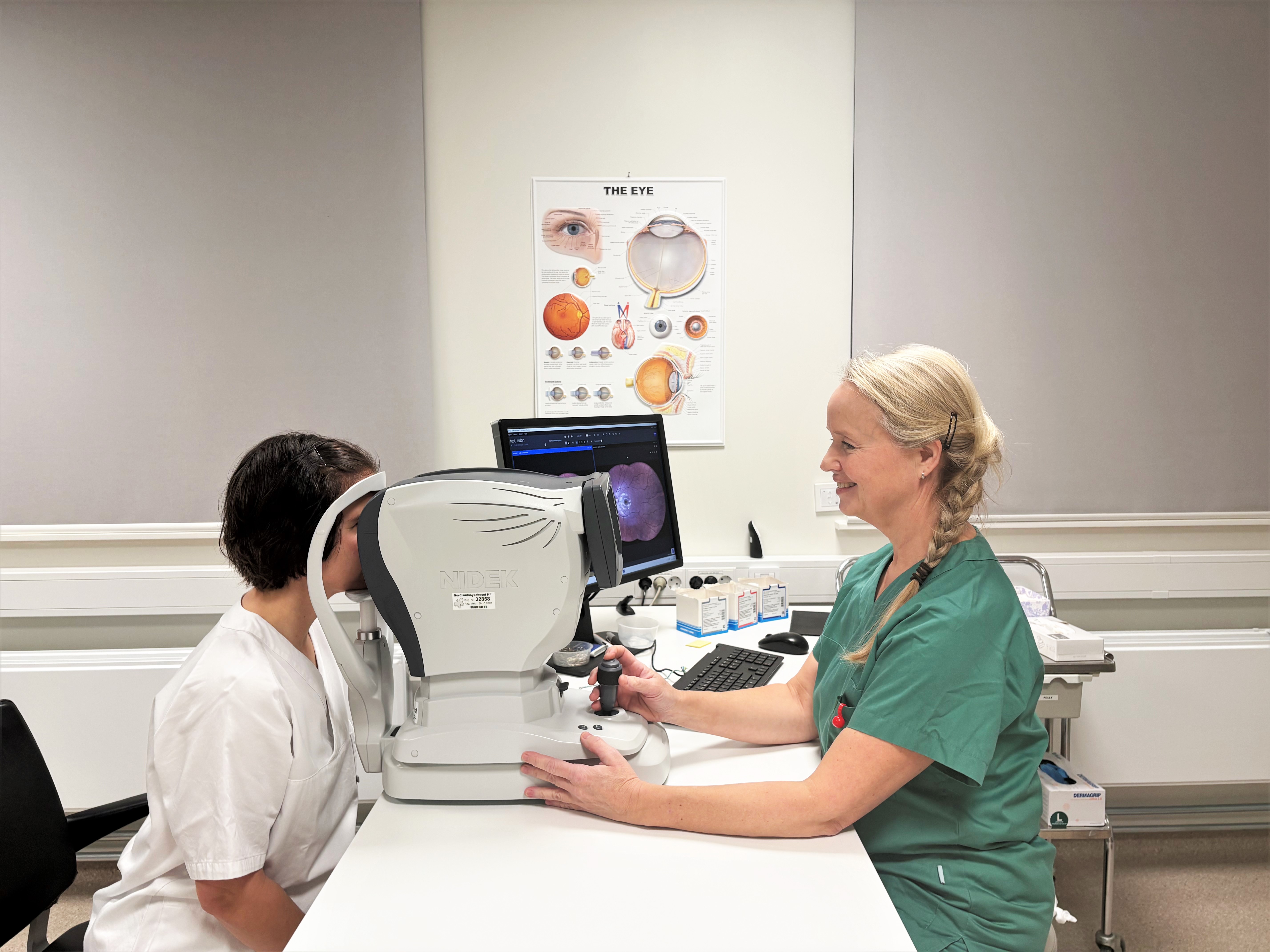 En lege som viser en pasient noe på datamaskinen