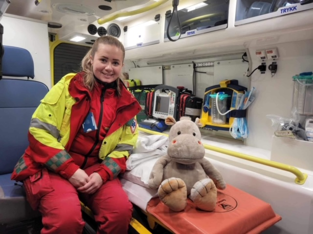 Bamse som sitter i sykebil sammen med ambulansearbeider