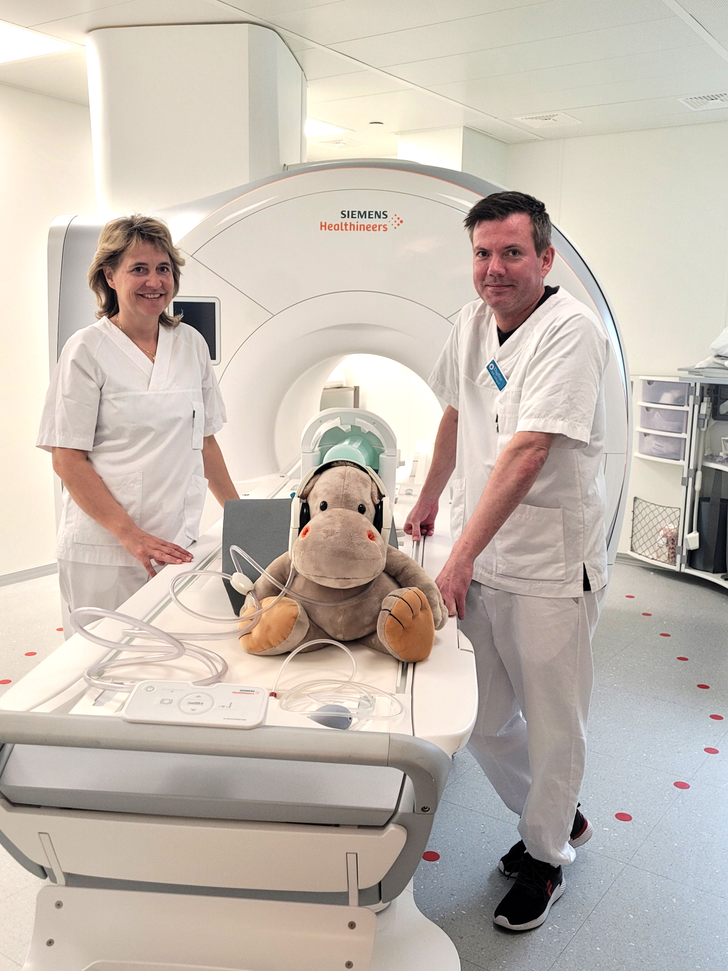 En mann og en kvinne som står sammen med en bamse