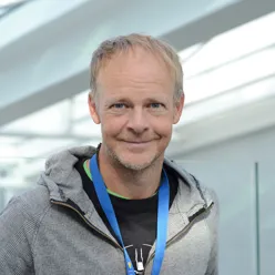 En mann som smiler til kameraet