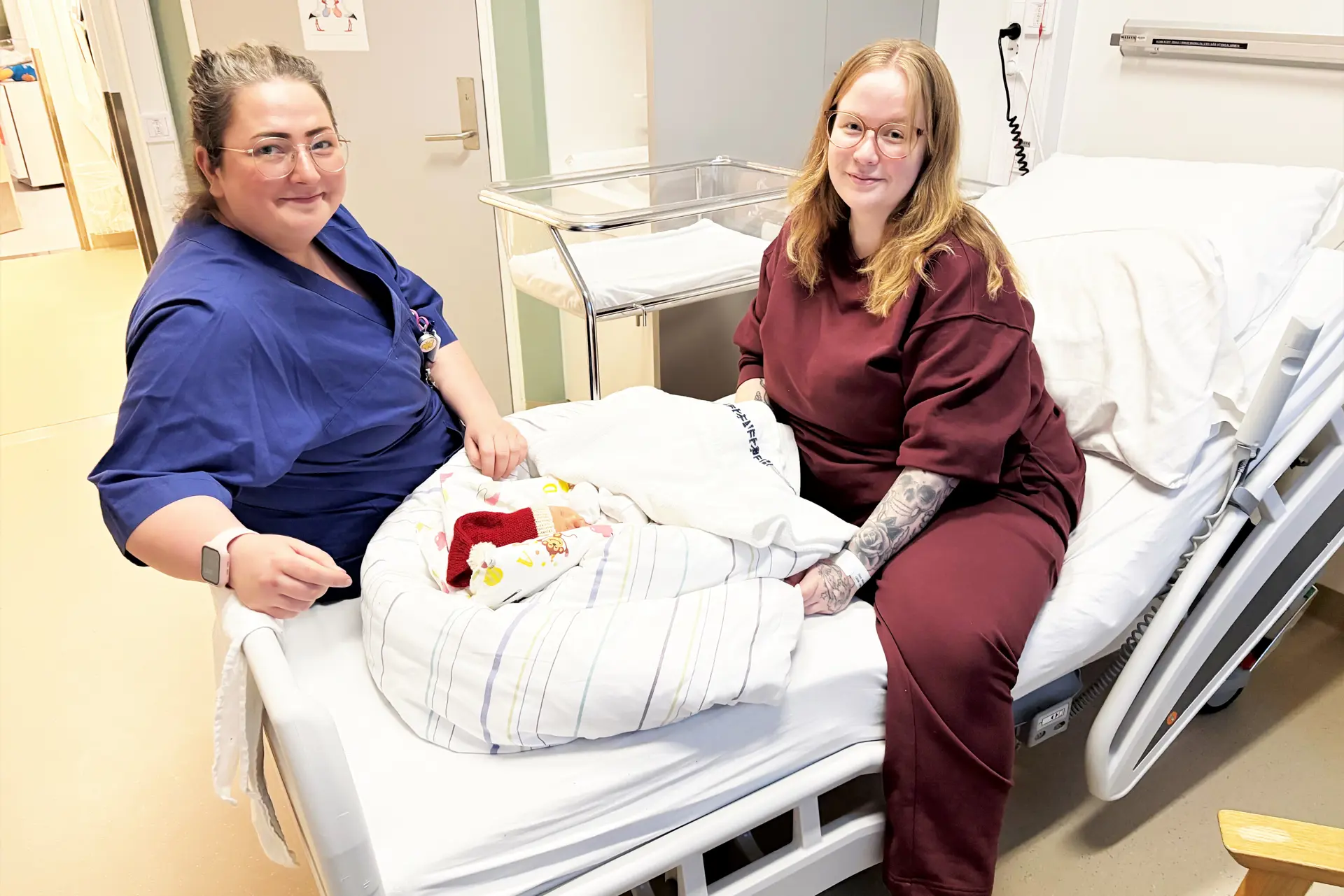 to damer som sitter i en seng med en baby