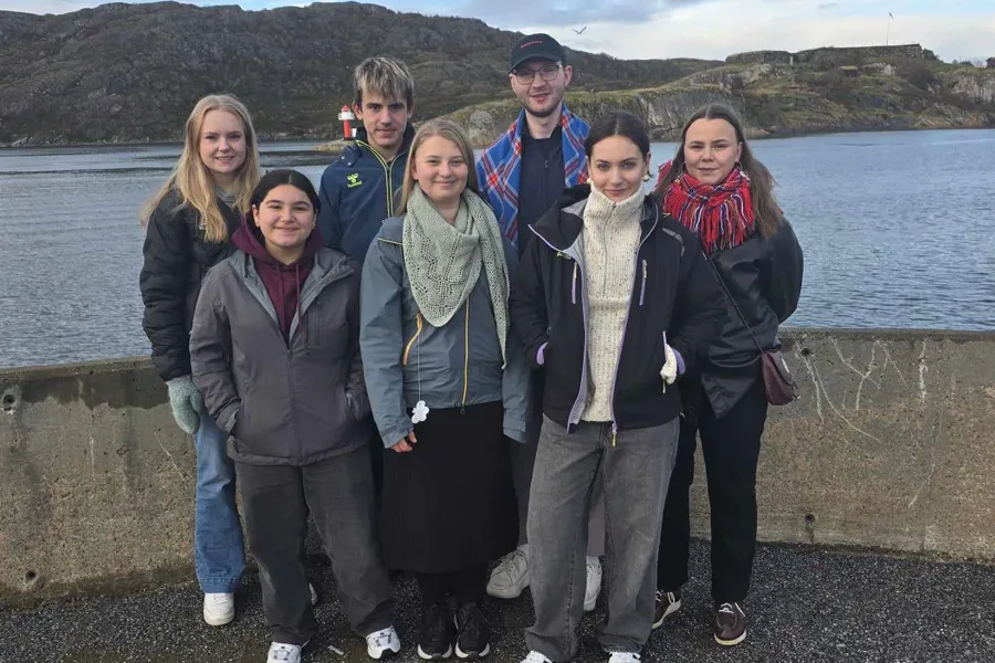 En gruppe mennesker som poserer for et bilde ved en vannmasse